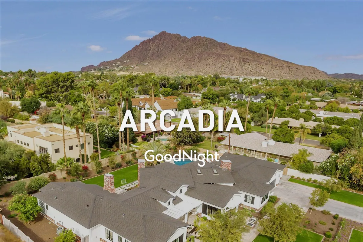 An exterior shot of the property featuring a spacious lawn, lush greenery, and a stunning mountain backdrop. Architectural details of the house are visible, and the outdoor space is inviting—perfect for relaxing after a productive workday.