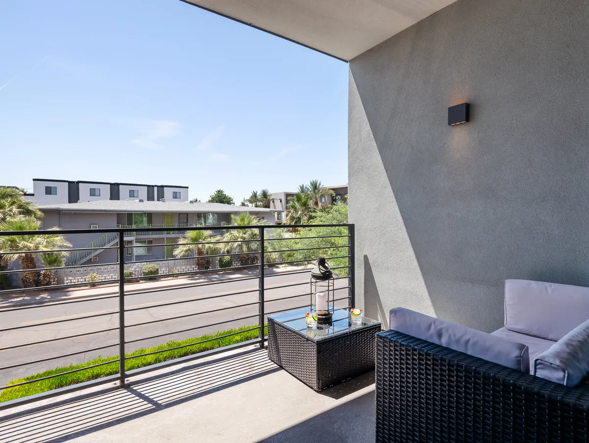 A tranquil balcony seating area overlooking the street, complete with decorative lanterns and comfortable chairs. The view invites relaxation, morning coffee, or evening conversation while enjoying the outdoors.
